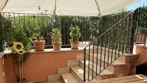 A covered outdoor area with a wooden bench, a metal staircase, and potted plants. - Apartment - Sleeps 3 &  swimming pool (Realmonte)