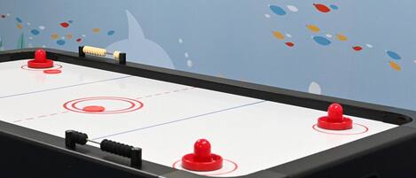 Ein Kicker mit vier roten Spielfiguren und einem schwarzen Spielstock.