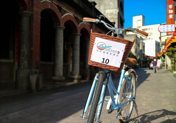 A blue bicycle with a wicker basket attached to the front, labeled with the number 10.