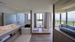 A modern bathroom with a large mirror, a bathtub, and a vanity. There is a view of the sea through large windows. - Lan Yang Seaview Hotel (Toucheng)