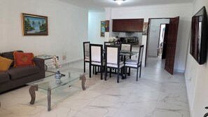 Un salon comprenant un canapé, une table basse et un coin repas avec des chaises et une table.