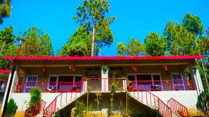 A two-story building with a red roof and balcony railings. - Majkhali Woods, Ranikhet, By Himalayan Eco Lodges (Ranikhet)