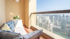 A balcony with a city view, a potted plant, and a sofa with patterned cushions. - Nasma Luxury Stays- Murjan 6, Jumeirah Beach Residence (Dubai)