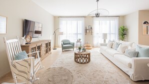 A living room with a sofa, a rocking chair, a coffee table, and a TV on a stand. - Nasma Luxury Stays- Murjan 6, Jumeirah Beach Residence (Dubai)