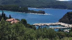 Eine Küstenlandschaft mit einem Hafen, Booten und einem Bergpanorama im Hintergrund.
