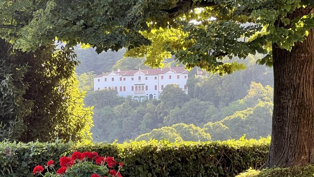 A large white building with red shutters, surrounded by lush greenery and trees. - Stunning 6-bed Private Villa With Pool Near Venice (Vicenza)