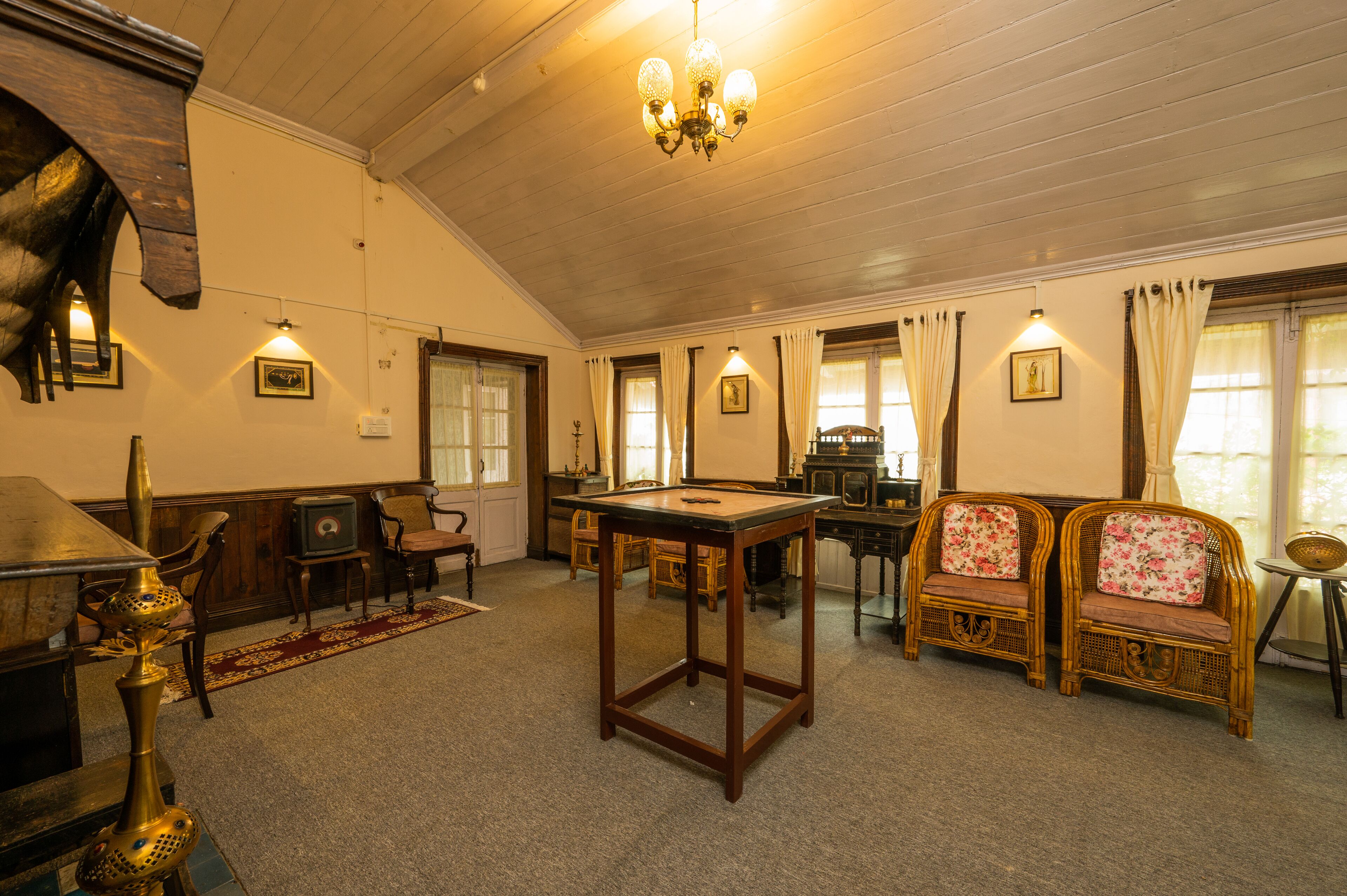 Una habitación con mesa de billar, muebles de madera y un candelabro.
