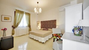 Habitación de hotel con cama, escritorio, silla, lámpara y un adorno sobre el escritorio.