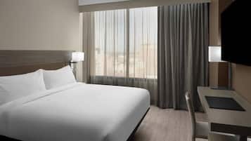 Une chambre d’hôtel avec un grand lit, un bureau et une télévision.