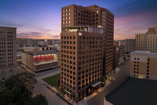 Un hotel moderno de gran altura, con una fachada roja llamativa y varios balcones.