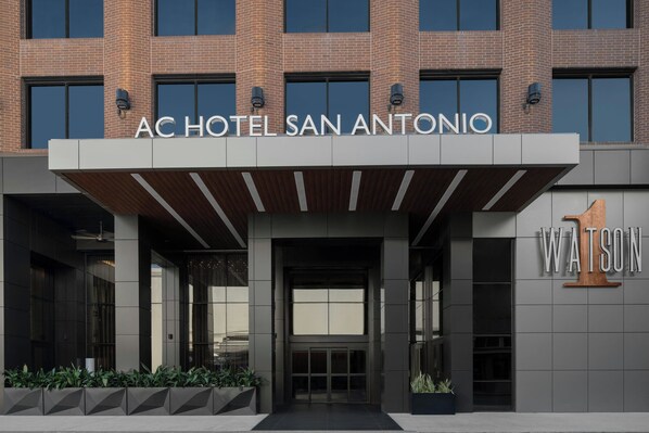 Das moderne Äußere des AC Hotels San Antonio, mit einem markanten Eingang und dem Schriftzug 'Watson' auf der rechten Seite.