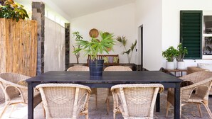 A dining area with a black table, wicker chairs, and potted plants. - CORONEL - CASERÍO DE GUAZA (Palm-Mar)