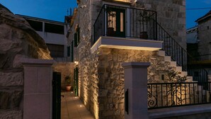 A stone building with a balcony and a staircase leading to the entrance. - Villa Bante - Luxury Stone House (Kastela)