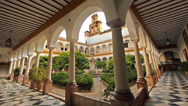Une cour intérieure agrémentée d’arcades, de colonnes et d’une fontaine.