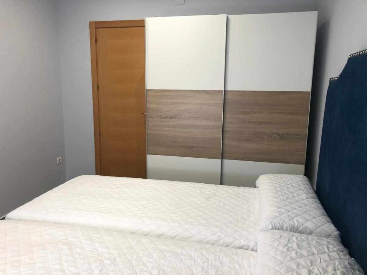 Un dormitorio con una cama, un armario de madera y un armario con espejo y acabado de madera.