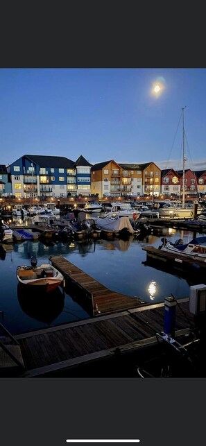A marina with docked boats and waterfront buildings.
