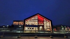 Un edificio con un letrero rojo llamativo que dice "Mickey's" de noche.