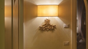 A hallway with a decorative wall lamp and a door. - San Lorenzo Apartment (Firenze)