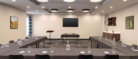 A conference room with long tables, chairs, and a piano.