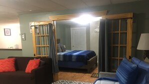 Ein Zimmer mit einem Bett, einem Sofa, einem Couchtisch und einer Lampe.
