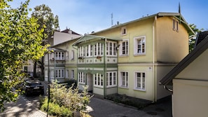 Un immeuble à plusieurs étages, doté d’une façade verdoyante, de nombreuses fenêtres et d’une enseigne indiquant clairement l’adresse.