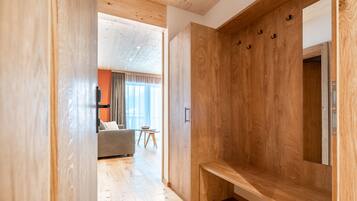 Un intérieur moderne avec un plancher en bois, un banc et un grand miroir.