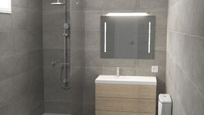 A modern bathroom with a shower, toilet, vanity, and a mirror. - Apartment with Pool View (Manacor)