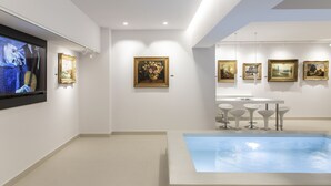 Una galería de arte con pinturas en las paredes y una fuente central.