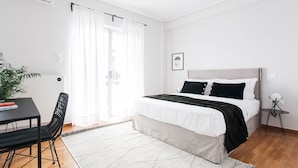 A bedroom with a bed, a desk, a chair, and a potted plant. - Spacious Apartment near HELEXPO (Marousi)