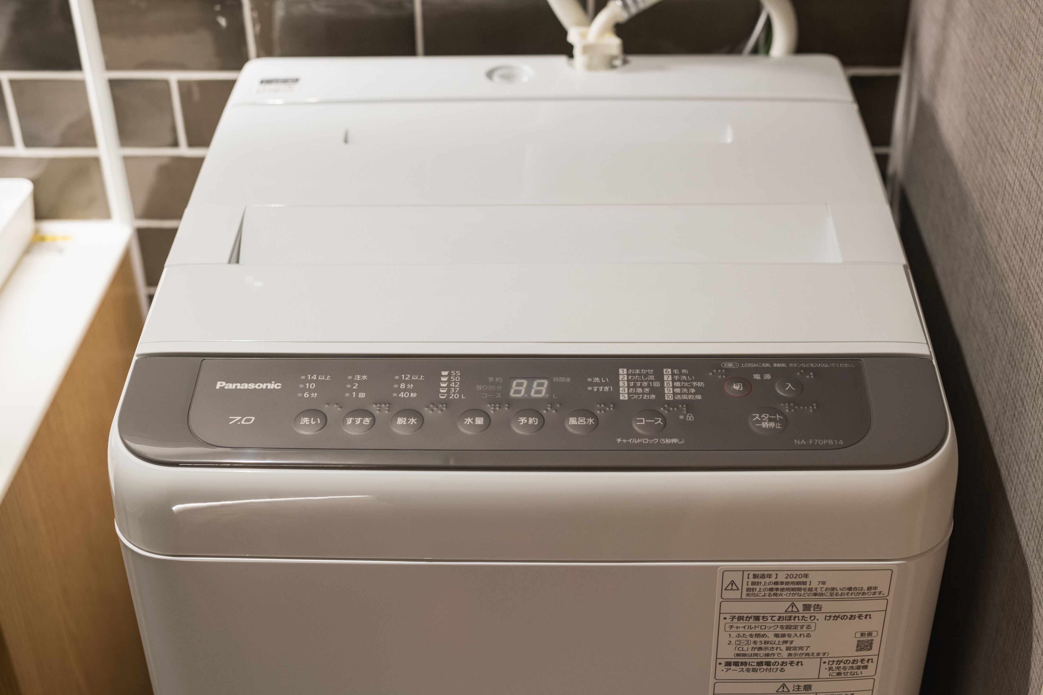 En hvid Panasonic 70 vaskemaskine med digitalt display og flere betjeningsknapper.