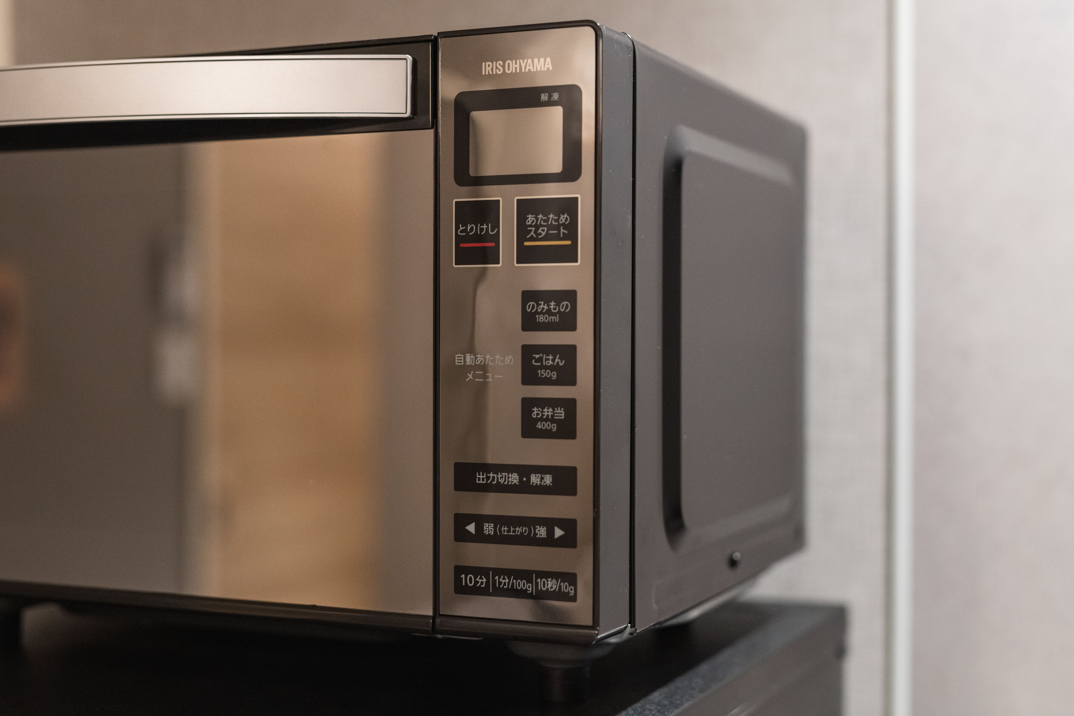 Een magnetron met een digitaal scherm en meerdere knoppen voor diverse functies.