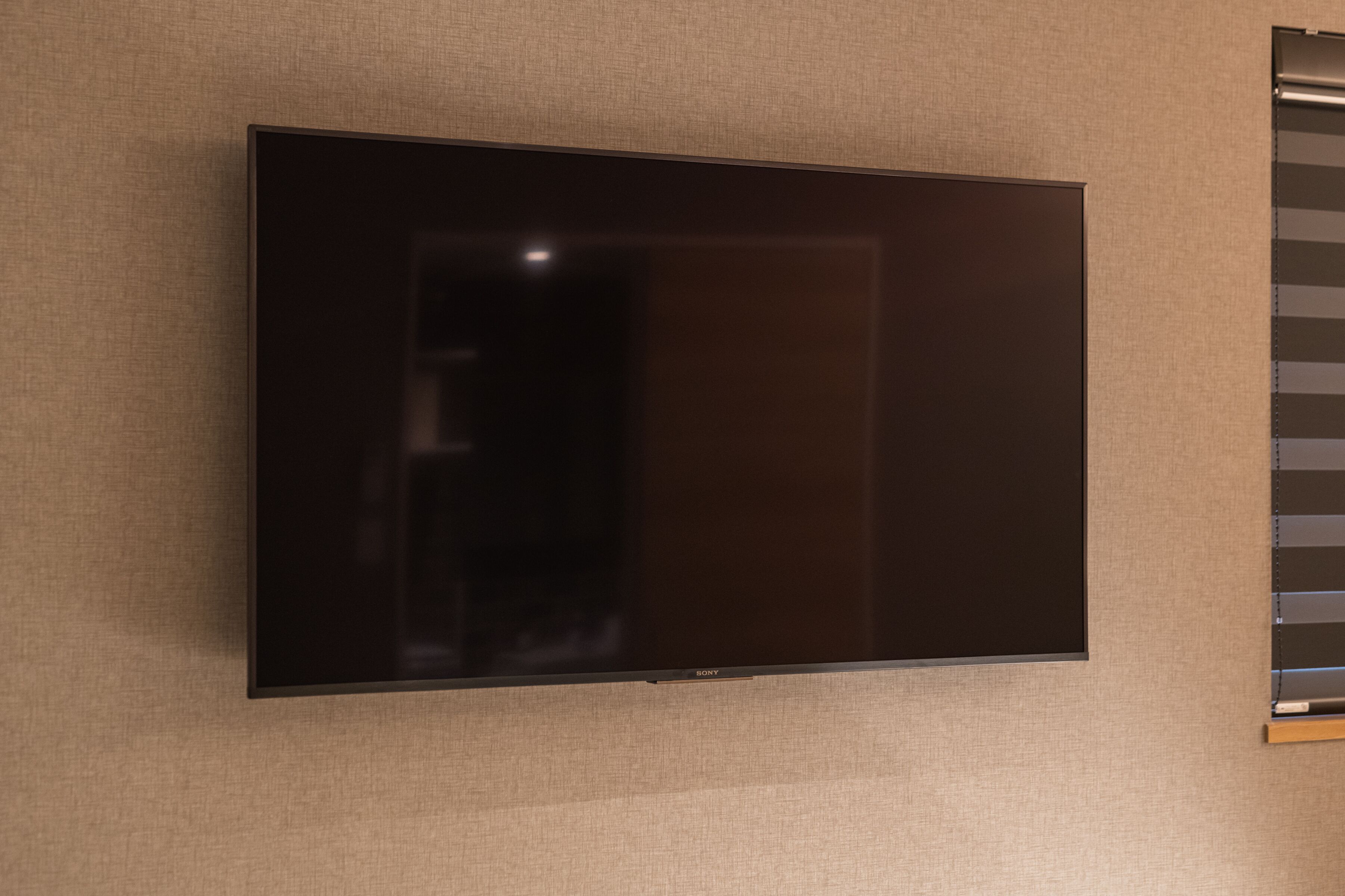A flat-screen TV mounted on a textured wall.