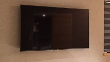 A flat-screen TV mounted on a textured wall.