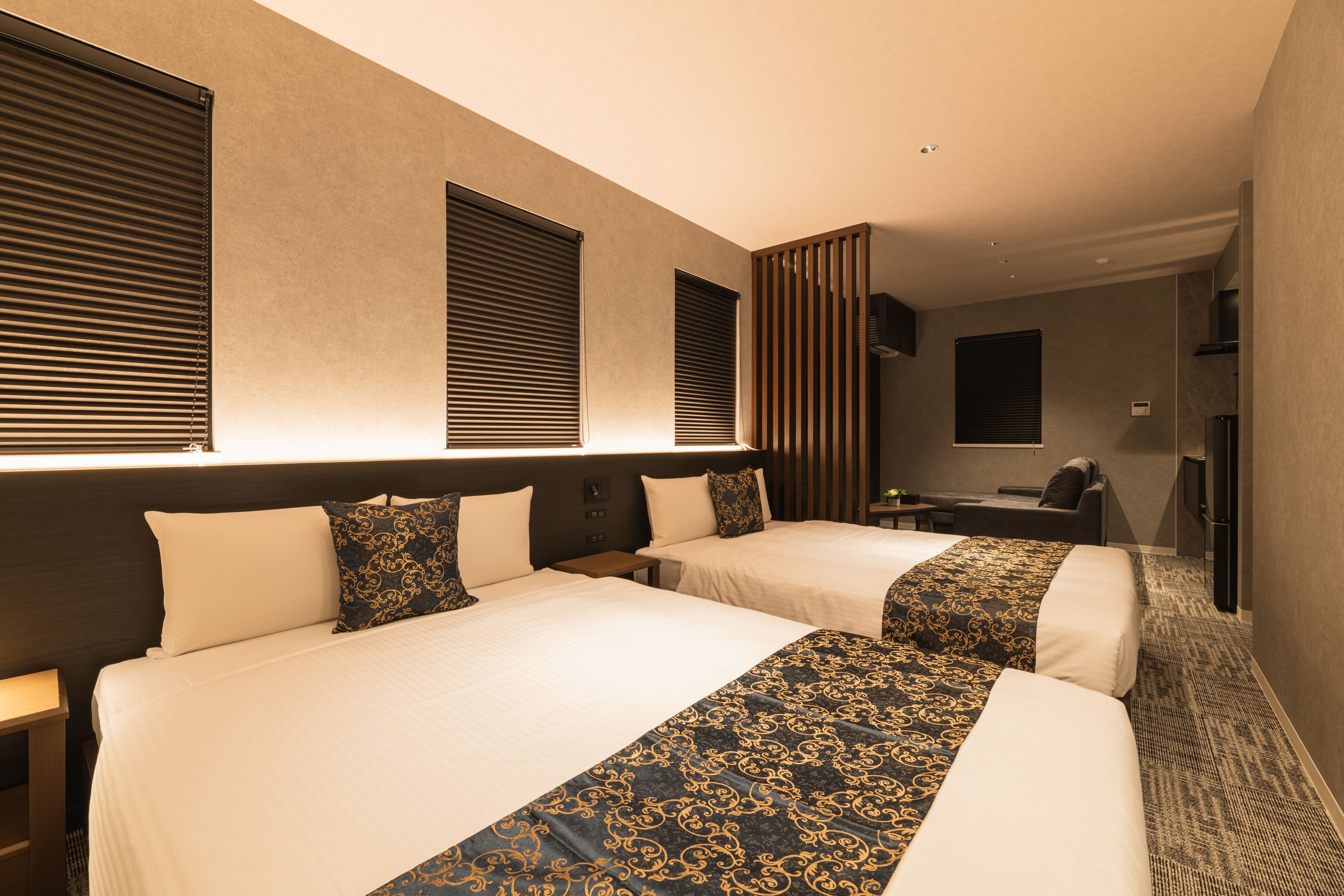 Une chambre d’hôtel avec deux lits, un bureau et une télévision.
