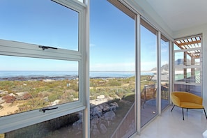 Una habitación con amplias ventanas que ofrecen vistas a la playa y al océano.