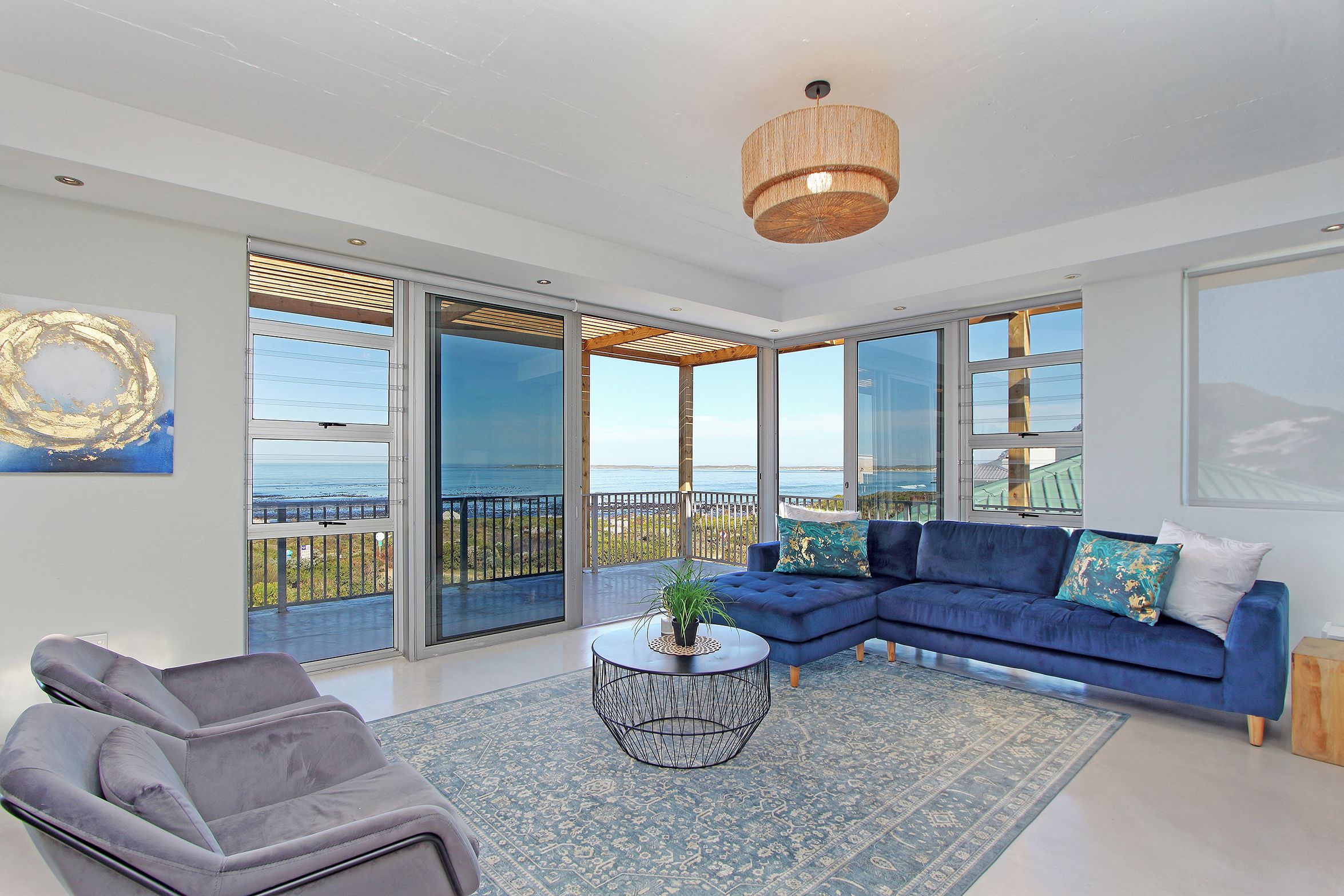 A modern living room with a blue sofa, a grey armchair, and a round coffee table.