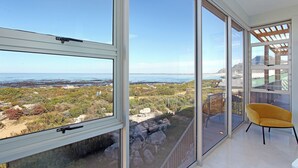 A room with large windows offering a view of the beach and ocean. - Blueview on Silversand (Betty's Bay)