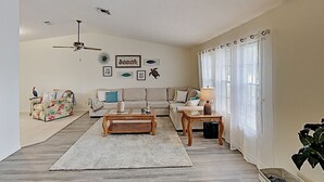 A living room with a sofa, coffee table, and decorative items. - Tiki Retreat (North Fort Myers)