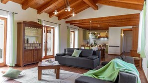 A spacious living area with a wooden ceiling, a sofa set, a dining table, and a kitchen in the background. - Modern Villa for 10 persons  is settled in the small village of Barban (Barban)