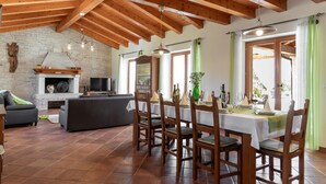 A spacious dining area with a high wooden ceiling, a brick fireplace, and a modern kitchen in the background. - Modern Villa for 10 persons  is settled in the small village of Barban (Barban)