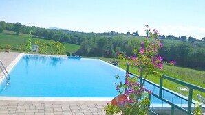 A swimming pool with a view of green hills in the background.