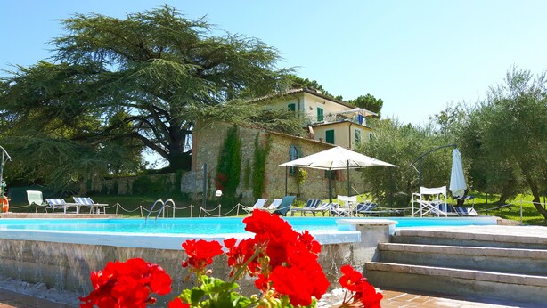 A pool area with lounge chairs and a building in the background. - Elegant villa on Lake Trasimeno - Fiordaliso (Ranciano)