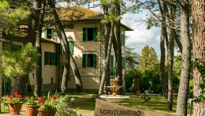 A villa with a sign reading "AGRITURISMO Villa La Fontana," surrounded by trees and potted plants. - Elegant villa on Lake Trasimeno - Fiordaliso (Ranciano)