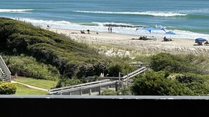 Una playa con gente, sombrillas y una vista despejada del océano.