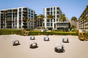 En la playa, sillas reclinables de playa, sombrillas, toallas de playa