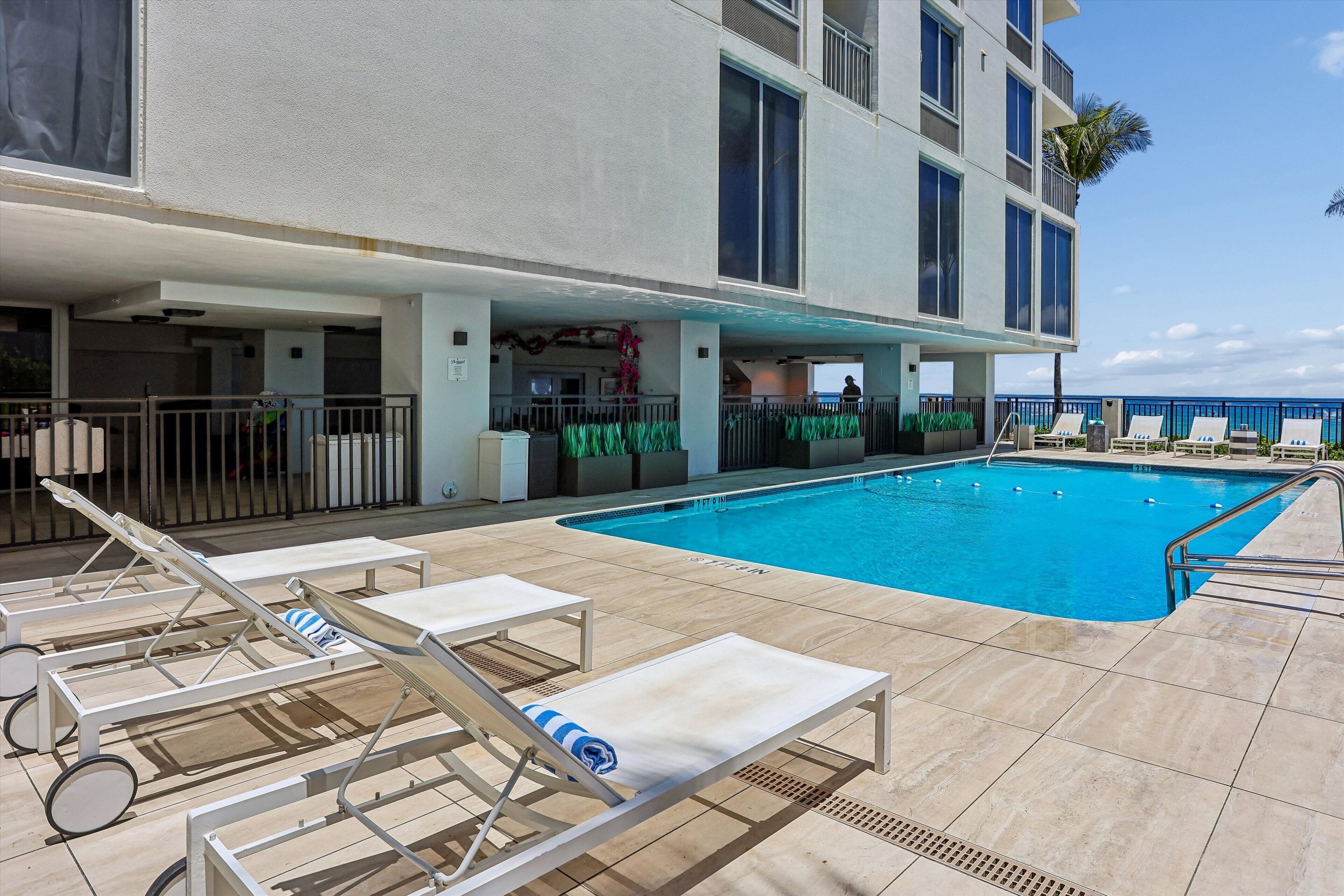 A pool area with sun loungers and a bar.