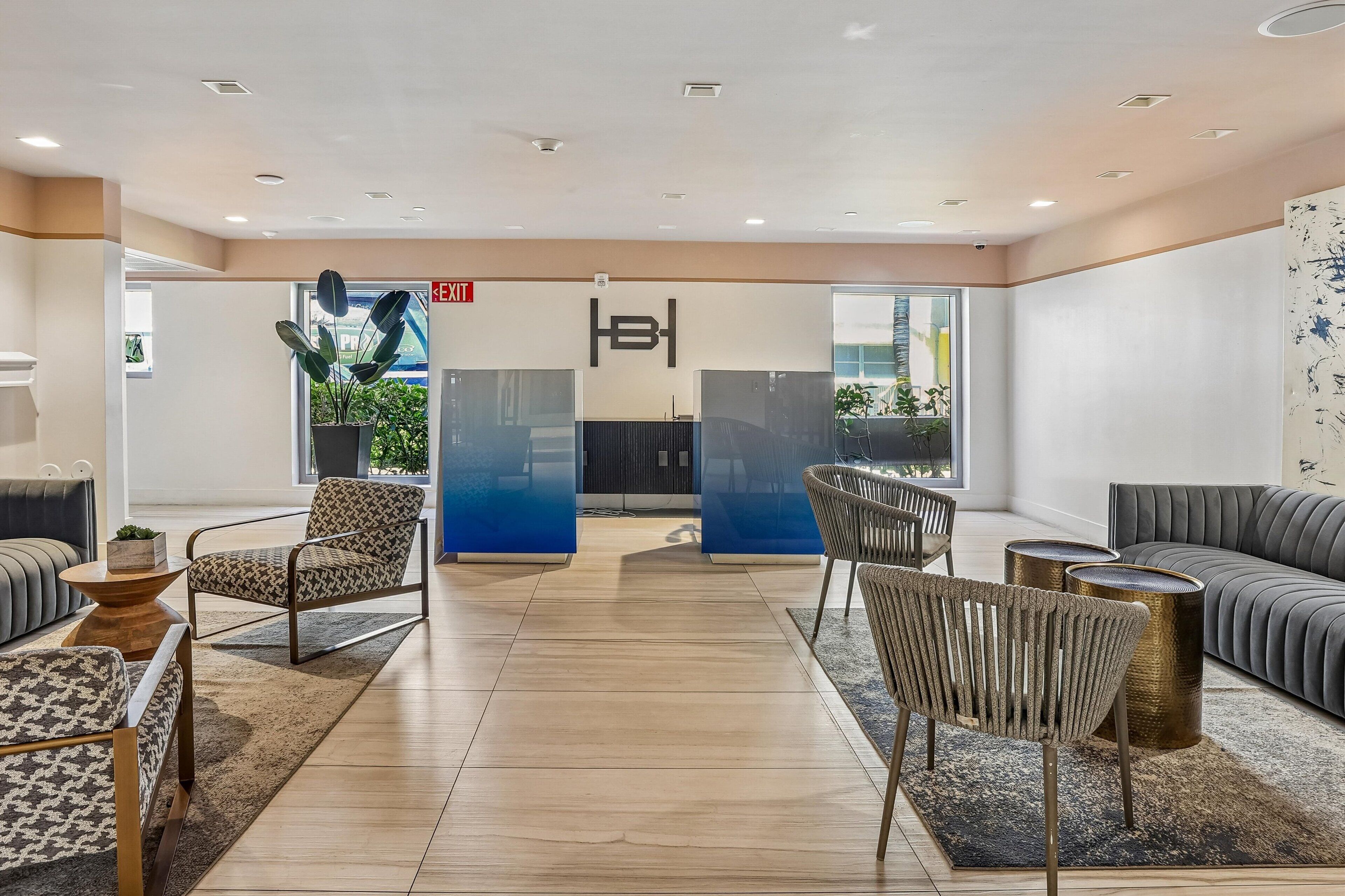 A modern lobby with a reception desk, seating area, and a view of the outside.