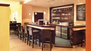 A bar area with a counter, stools, and shelves stocked with bottles and glasses. - Vacation apartment in Haus Wiesenblume: Apartment 1 (Willingen-Usseln)