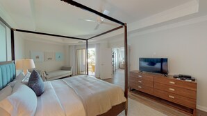A four-poster bed with a TV and a wooden dresser in a hotel room. - Sophisticated Ocean View Residence located at The Ritz-Carlton (Seven Mile Beach)