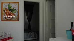 Une pièce avec un lit, une table avec des verres et un tableau au mur.